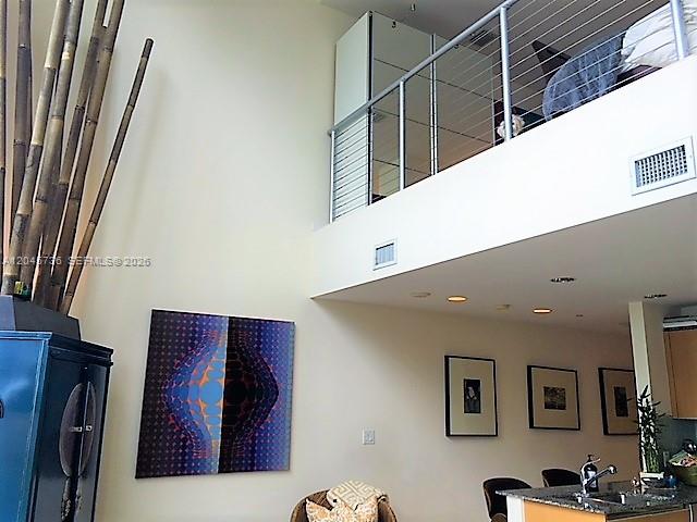 A living room with high ceilings, a loft level, and modern wall art — MIAMI, FL