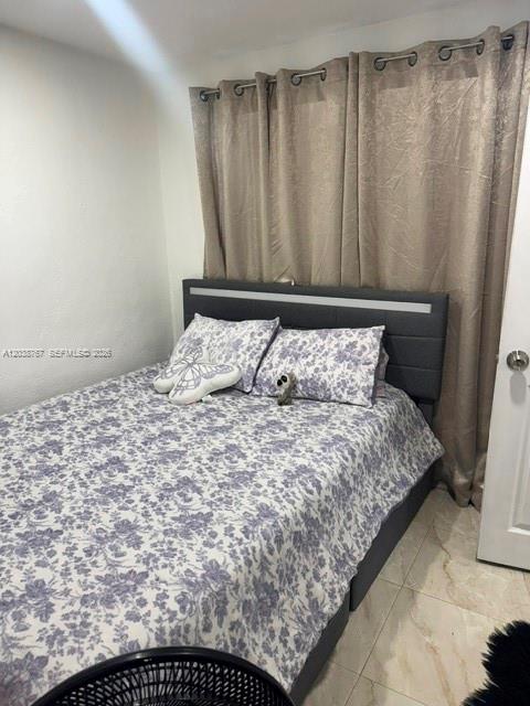 A bedroom features a bed with a floral comforter, a gray headboard, and beige curtains — 211 SW 71st Ave, Miami FL 33144, MIAMI, FL