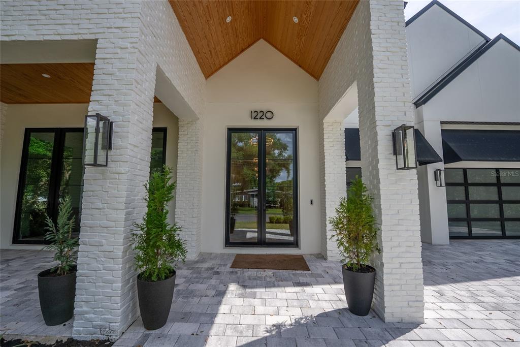 The front entrance features a white brick facade, a wood-paneled ceiling, and double glass doors — 1220 DELANEY PARK DRIVE, ORLANDO, FL