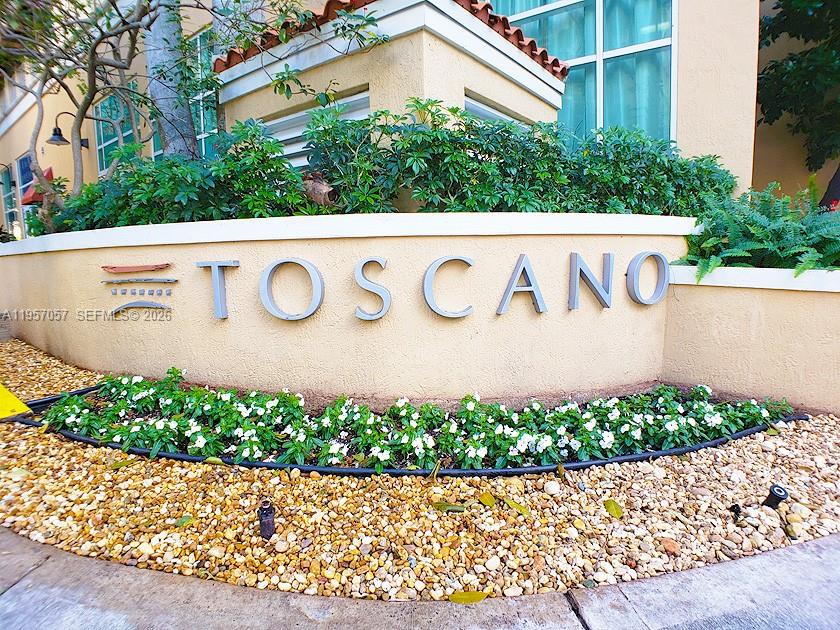 A beige curved wall features the word TOSCANO in metal letters with landscaping in front — 7350 SW 89th St # 1611S, Miami FL 33156, MIAMI, FL