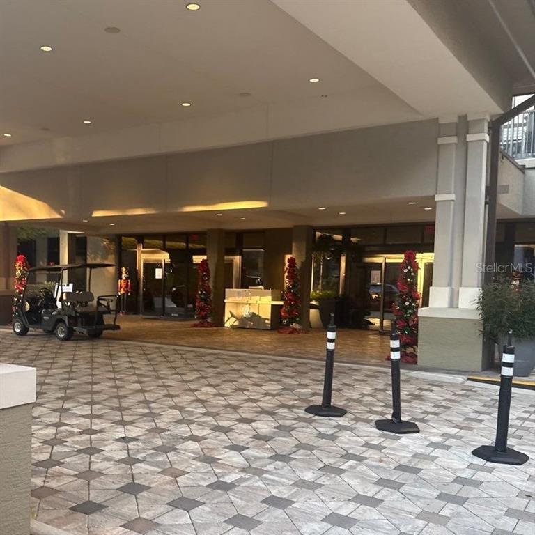 A covered entrance features a paved driveway, a golf cart, and holiday decorations — 14501 GROVE RESORT AVENUE UNIT 2604, WINTER GARDEN, FL