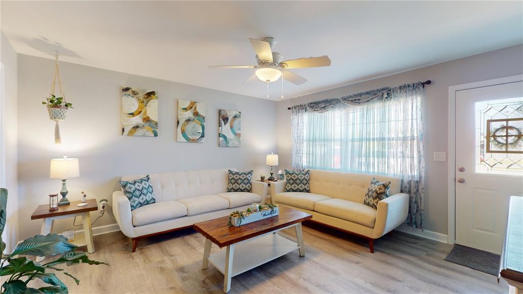 A living room features two cream sofas, a wooden coffee table, and a ceiling fan — 20407 ALBURY DRIVE, PORT CHARLOTTE, FL