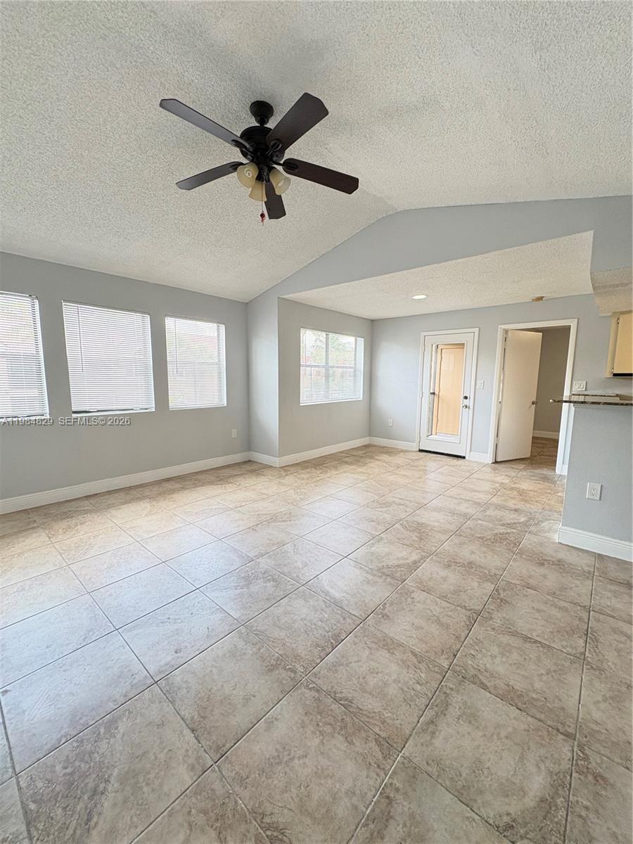 A living area features light gray walls, a vaulted ceiling with a fan, and tiled floors — 10501 SW 155th Ct # 1124, Miami FL 33196, MIAMI, FL
