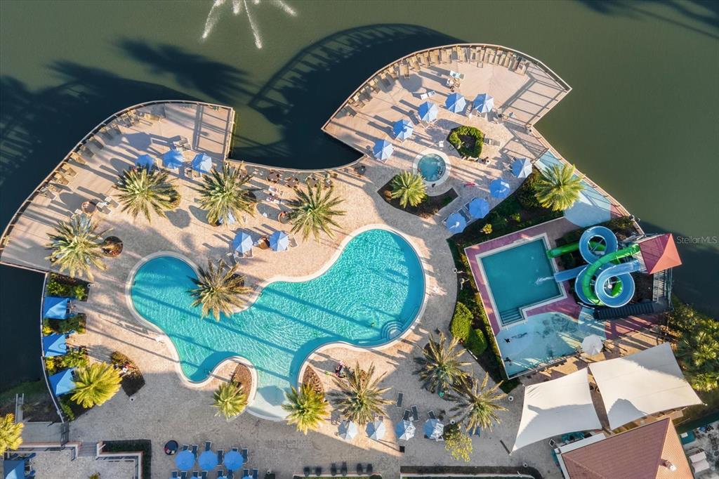 An aerial view shows a resort-style swimming pool with water slides and lounge chairs — 2630 CORVETTE LANE, KISSIMMEE, FL