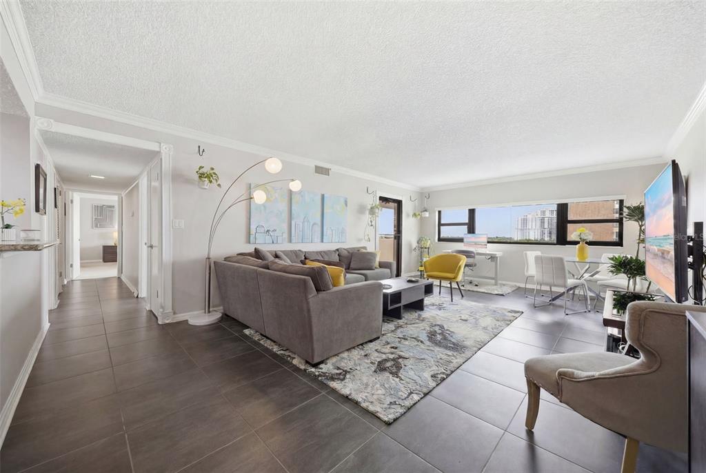 A living room with gray tile flooring, a sectional sofa, and a large window view — 4141 BAYSHORE BOULEVARD UNIT 706, TAMPA, FL