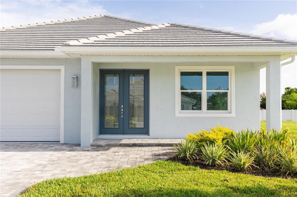 The exterior of a light blue house features a double front door and a garage — 5213 WILLOW LAKE COURT, SARASOTA, FL