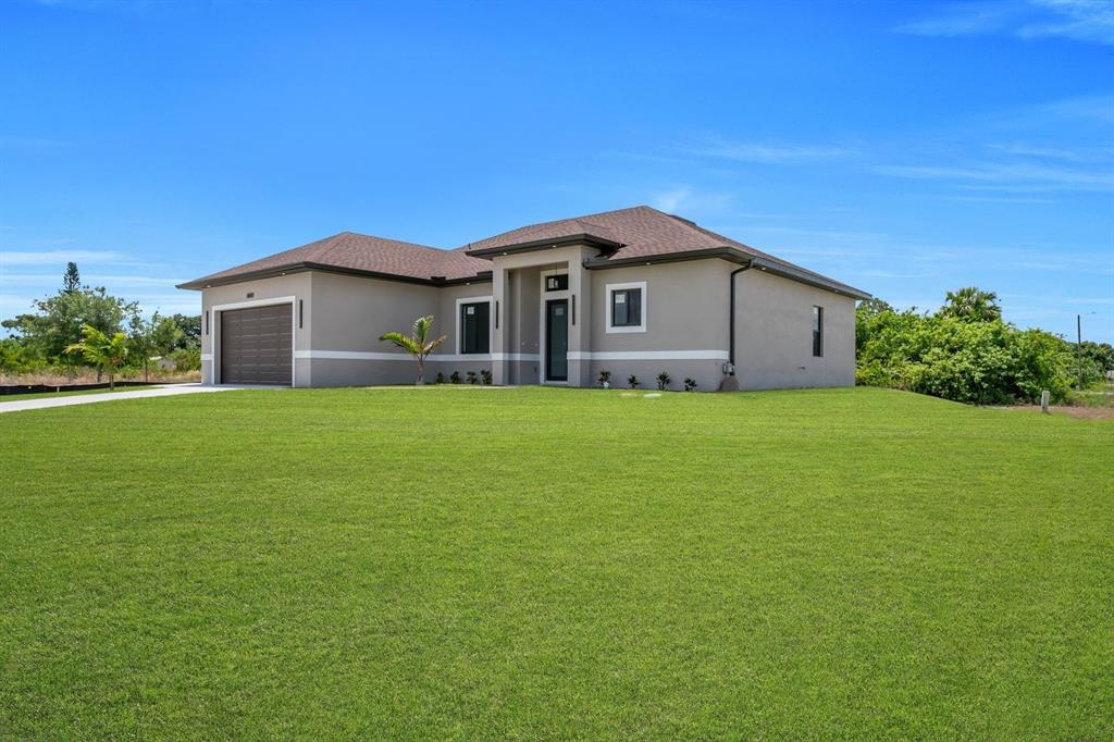 A single-story house with a brown roof, gray stucco exterior, and an attached garage — 3115 2ND STREET SW, LEHIGH ACRES, FL