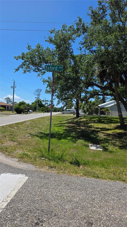 A street sign for Oxford Ave stands in a grassy area near a paved road — 18342 OXFORD AVENUE, PORT CHARLOTTE, FL