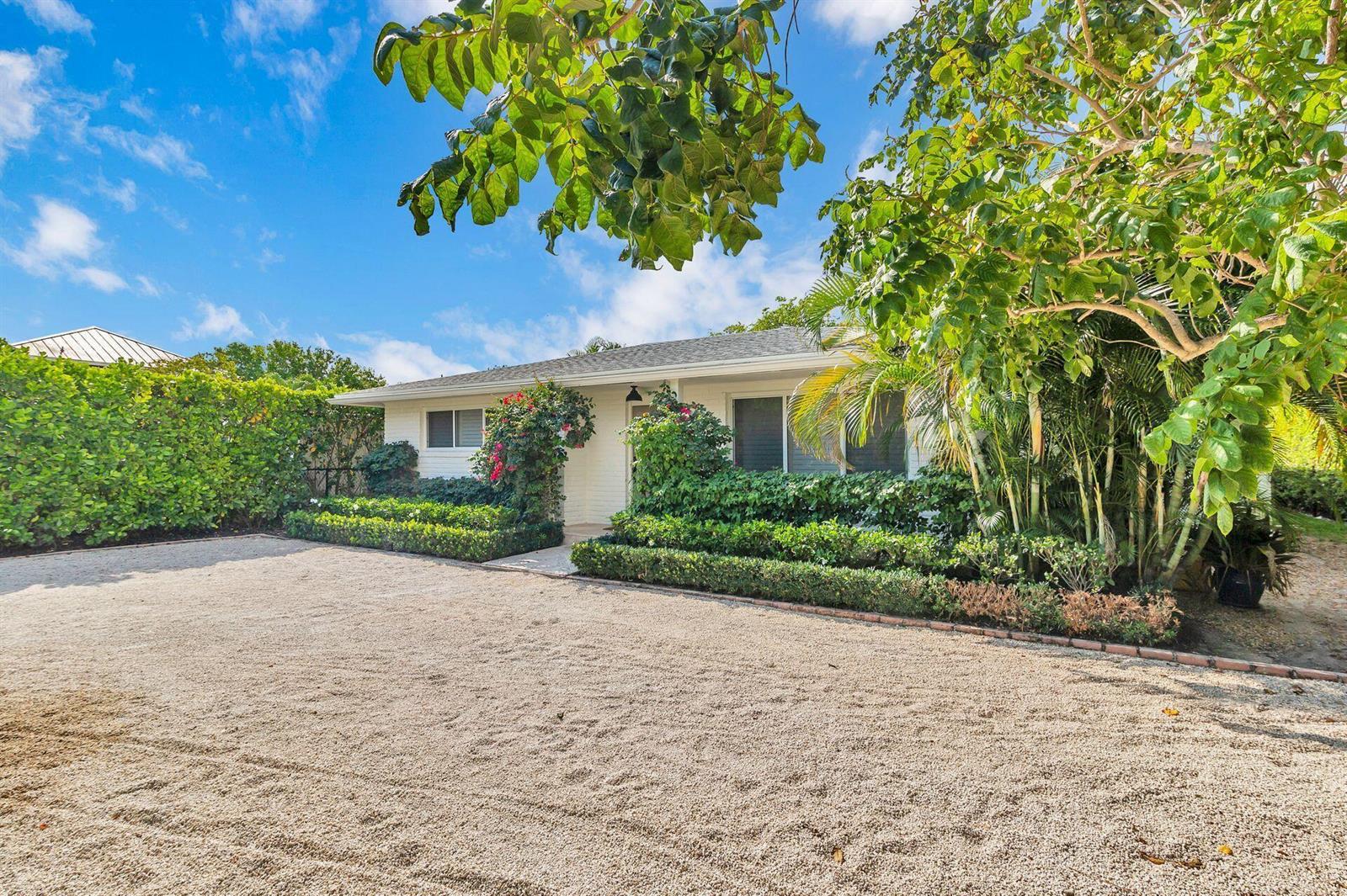 A white single-story house with a gravel driveway and lush landscaping under a blue sky — 246 Gray Street, West Palm Beach FL 33405, WEST PALM BEACH, FL