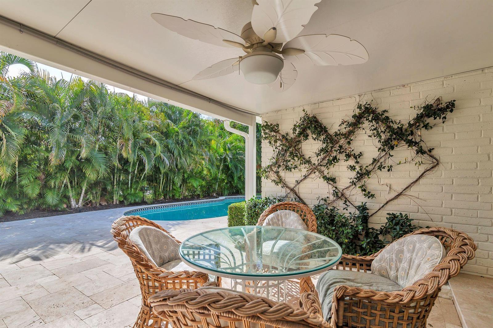 A covered patio with wicker furniture, a glass table, and a view of a swimming pool — 246 Gray Street, West Palm Beach FL 33405, WEST PALM BEACH, FL