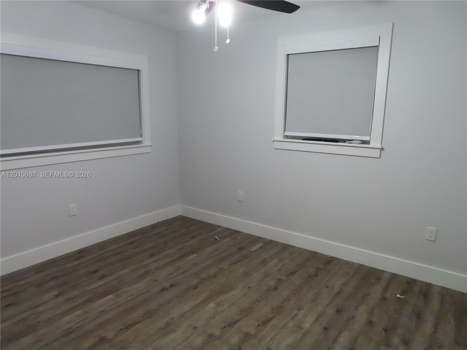 An empty bedroom features light gray walls, white trim, and wood-look flooring — 2433 NW 96th St # B, Miami FL 33147, MIAMI, FL