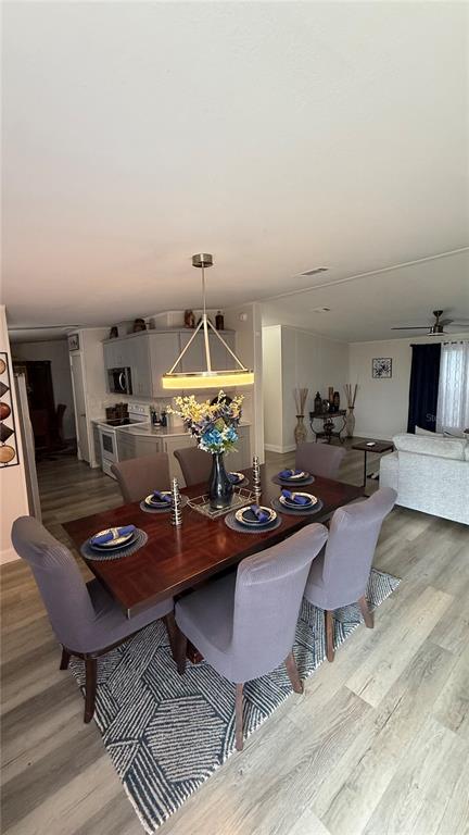 A dining area features a wooden table with six gray chairs on a patterned rug — 747 ISLAND STREET, DAVENPORT, FL