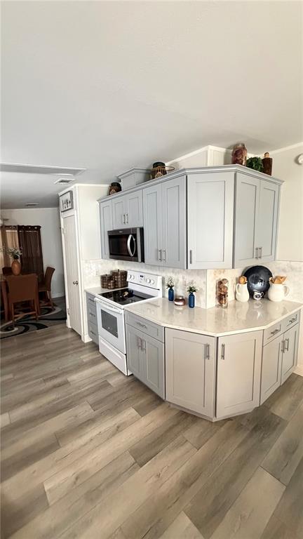 A kitchen features light gray cabinets, white countertops, and wood-look flooring — 747 ISLAND STREET, DAVENPORT, FL