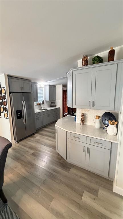 A kitchen features light gray cabinets, stainless steel appliances, and wood-look flooring — 747 ISLAND STREET, DAVENPORT, FL