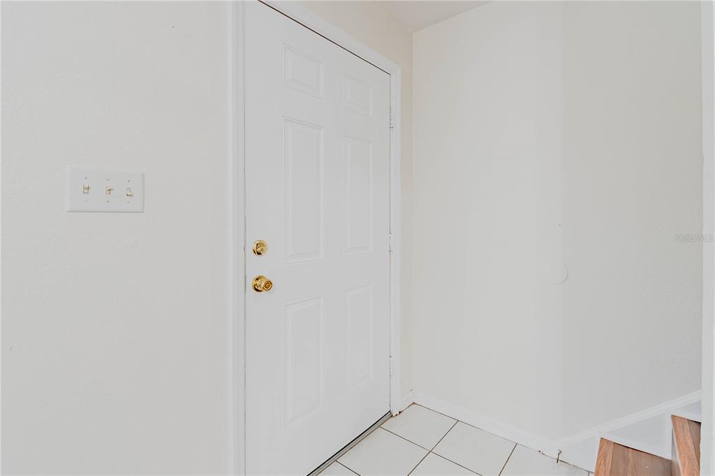 A white door with gold hardware is set in a room with white walls — 13538 EMBASSY PARK COURT UNIT 44A2, DADE CITY, FL