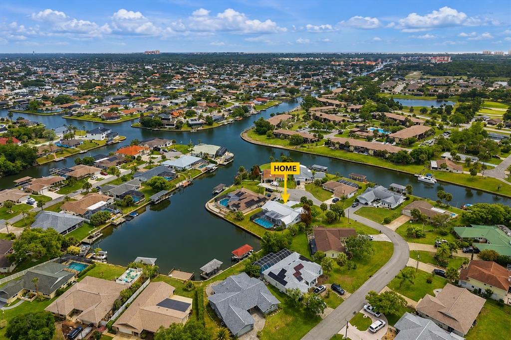 An aerial view shows a waterfront house with a pool in a suburban neighborhood — 31 FLEMING COURT, PALM COAST, FL