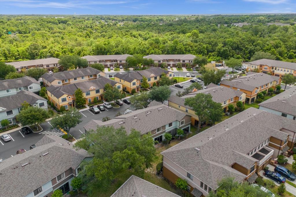 An aerial view shows multiple multi-story apartment buildings surrounded by parking lots and trees — 3360 WINDLESHORE WAY, SANFORD, FL
