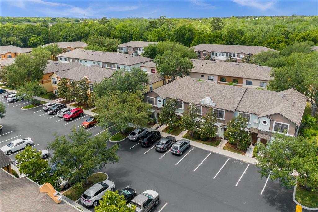 An aerial view shows multi-story apartment buildings with parking lots and surrounding trees — 3360 WINDLESHORE WAY, SANFORD, FL