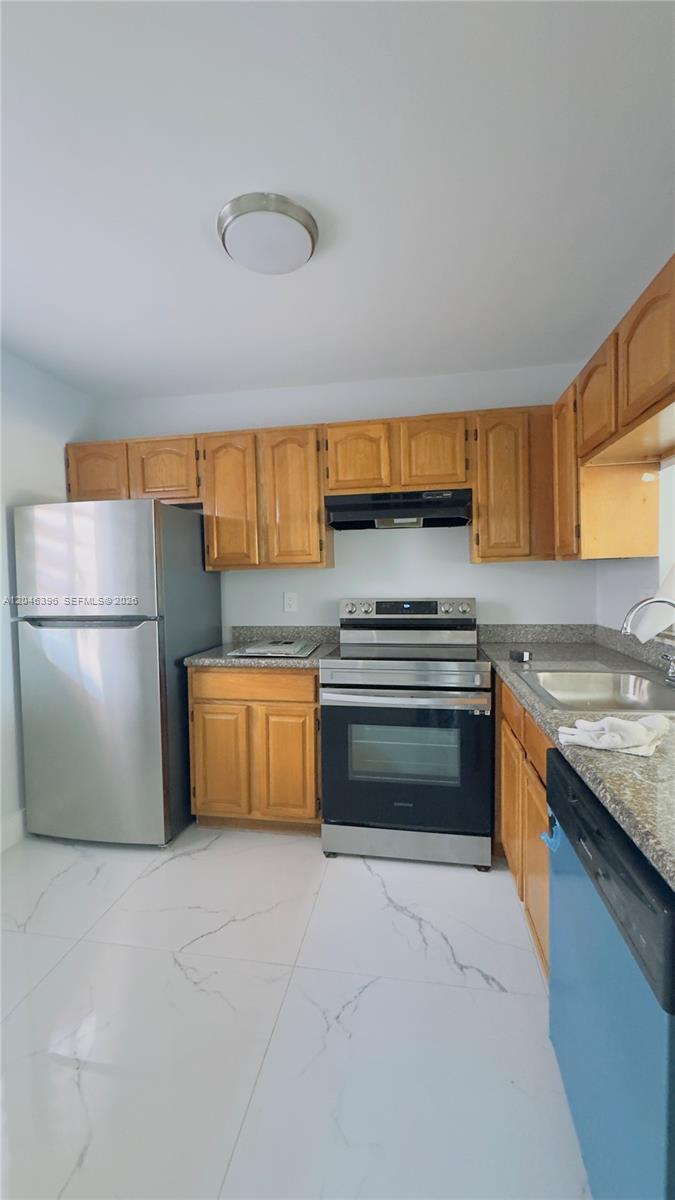 A kitchen features wood cabinets, stainless steel appliances, granite countertops, and white marble-patterned tile floors — 19851 SW 114th Ave # 301, Miami FL 33157, MIAMI, FL