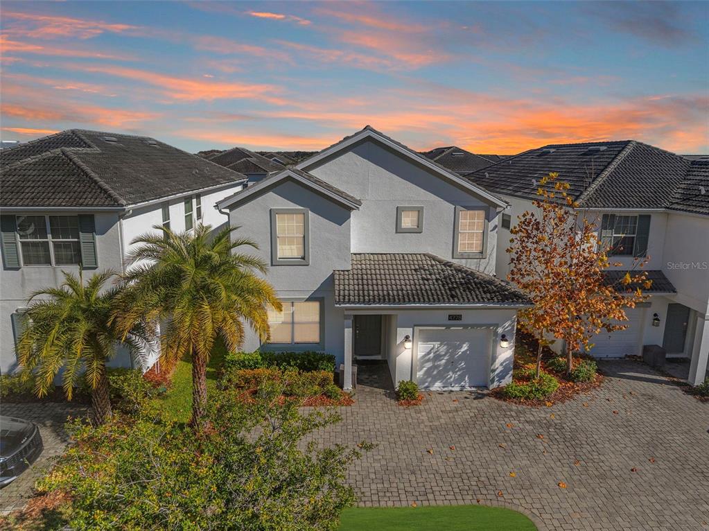 A two-story stucco house with a tiled roof, a single-car garage, and a paved driveway — 4778 KINGS CASTLE CIRCLE, KISSIMMEE, FL