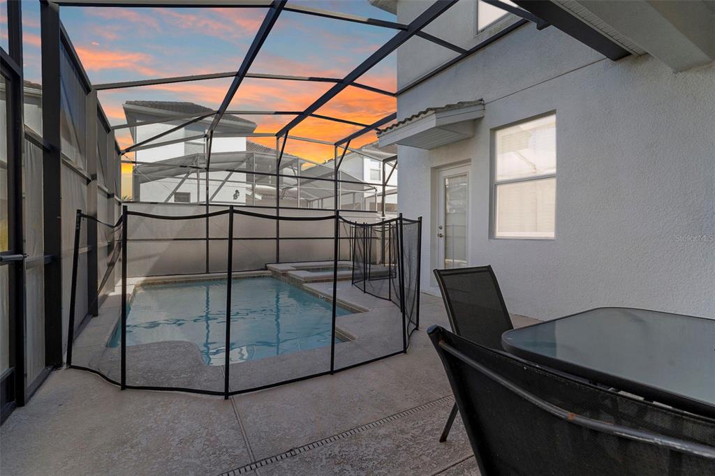 A screened-in patio features a small swimming pool with a safety fence and outdoor furniture — 4778 KINGS CASTLE CIRCLE, KISSIMMEE, FL