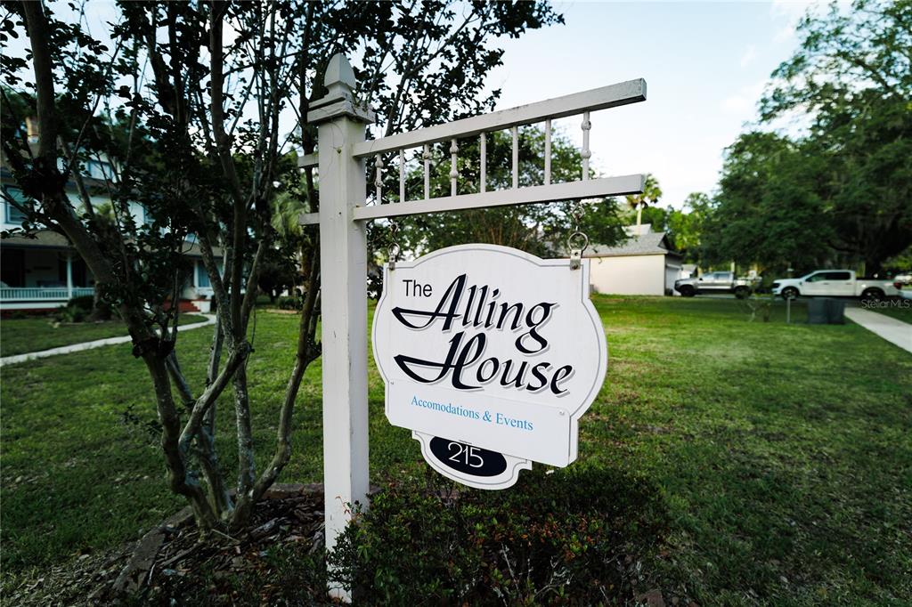 A white sign for The Alling House stands in a grassy yard near a house — 215 E FRENCH AVENUE, ORANGE CITY, FL