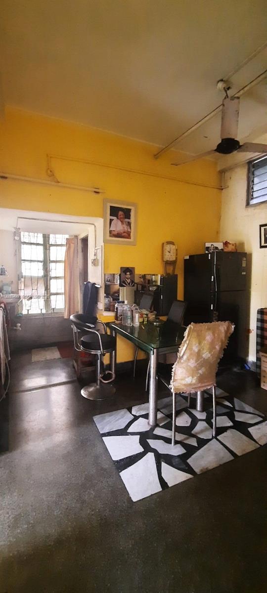 A dining area with a glass table, chairs, and a refrigerator against a yellow wall — 2/1 Rajani Mukherjee Road, Kolkata, India, 700038, FL