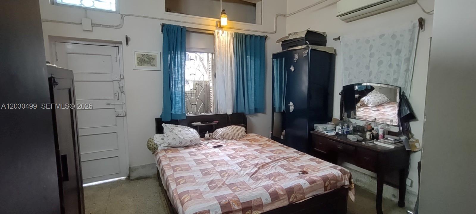 A bedroom features a bed, a dark wardrobe, a vanity with a mirror, and blue curtains — 2/1 Rajani Mukherjee Road, Kolkata, India, 700038, FL