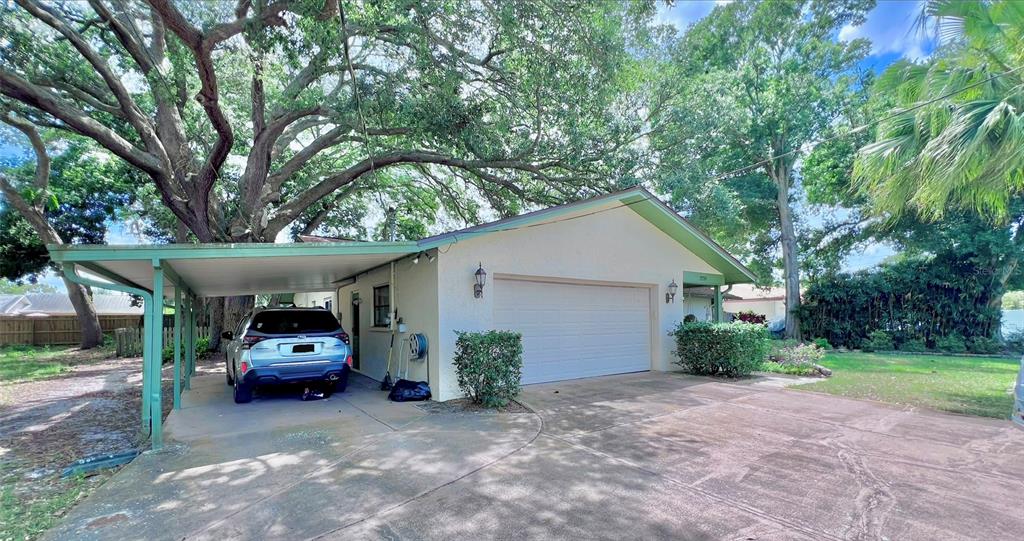 A single-story house with a white exterior, a two-car garage, and a large front lawn — 2219 ALICE LANE, CLEARWATER, FL