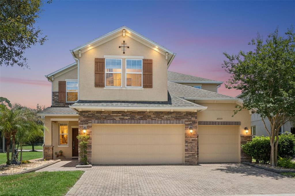 A two-story house with a stone-accented facade, two garage doors, and a paved driveway — 10555 ARBOR VIEW BOULEVARD, ORLANDO, FL
