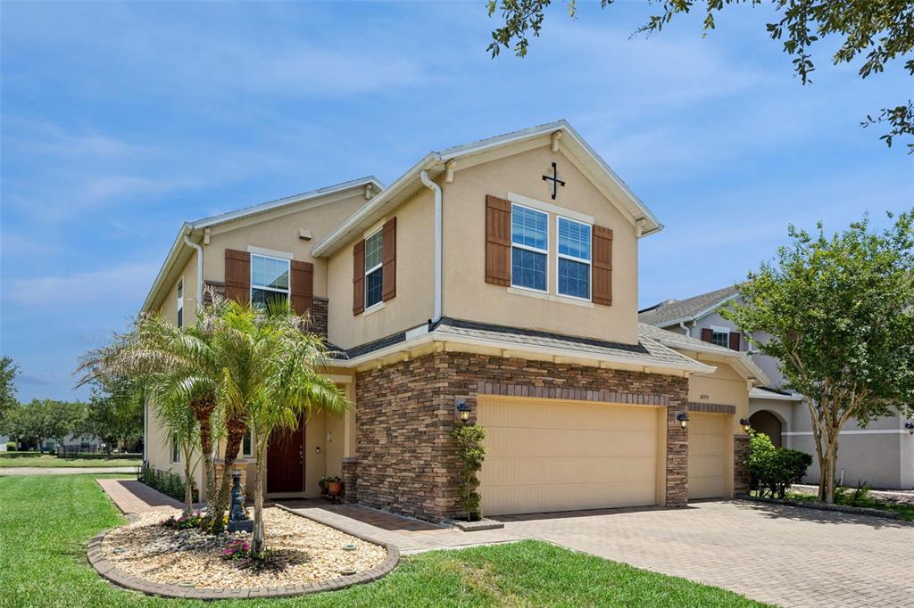 A two-story house with a stone-veneer facade, a two-car garage, and a palm tree — 10555 ARBOR VIEW BOULEVARD, ORLANDO, FL