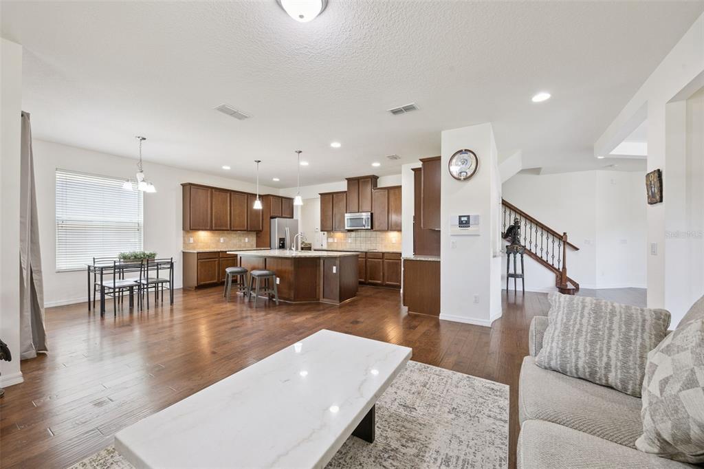 An open-concept kitchen with dark wood cabinets, a central island, and hardwood flooring — 10555 ARBOR VIEW BOULEVARD, ORLANDO, FL