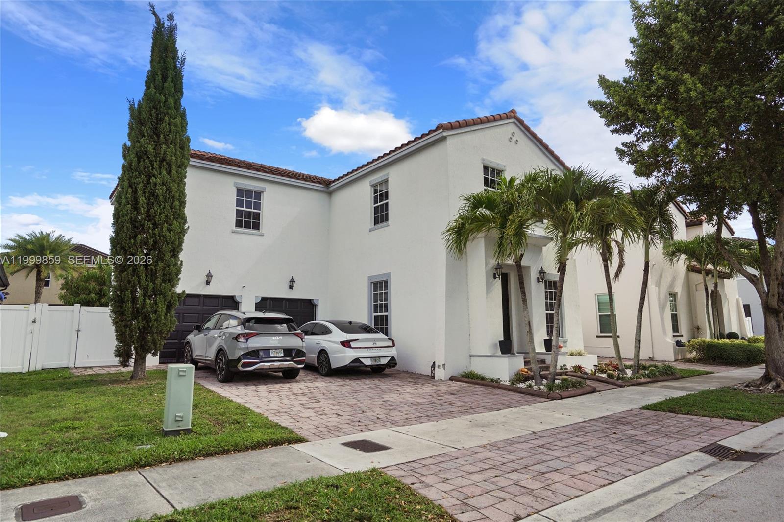 A two-story white stucco house features a paved driveway, two parked cars, and palm trees — 17081 SW 94th Way, Miami FL 33196, MIAMI, FL