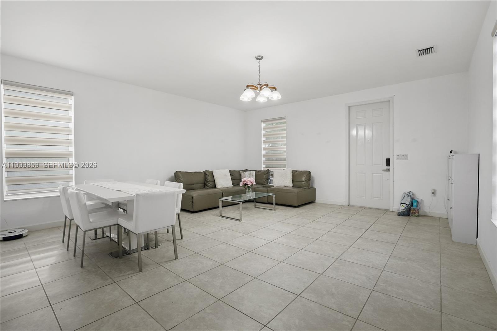 A living and dining area features white walls, tile flooring, and a sectional sofa — 17081 SW 94th Way, Miami FL 33196, MIAMI, FL