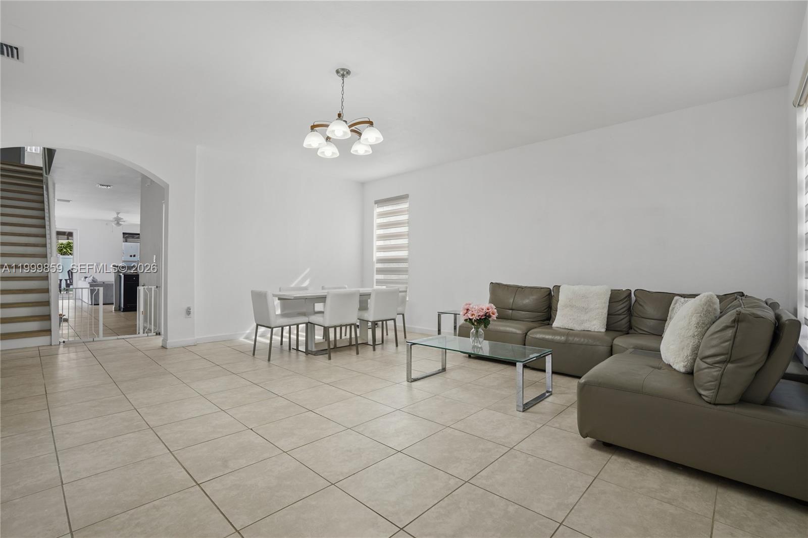 A living and dining area features tile floors, white walls, and a grey sectional sofa — 17081 SW 94th Way, Miami FL 33196, MIAMI, FL