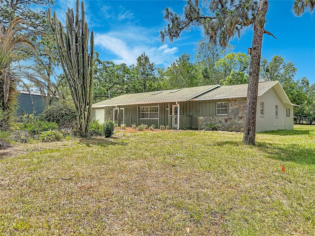 A single-story house with stone siding and a large cactus in the front yard — 13206 TYRONE STREET, HUDSON, FL