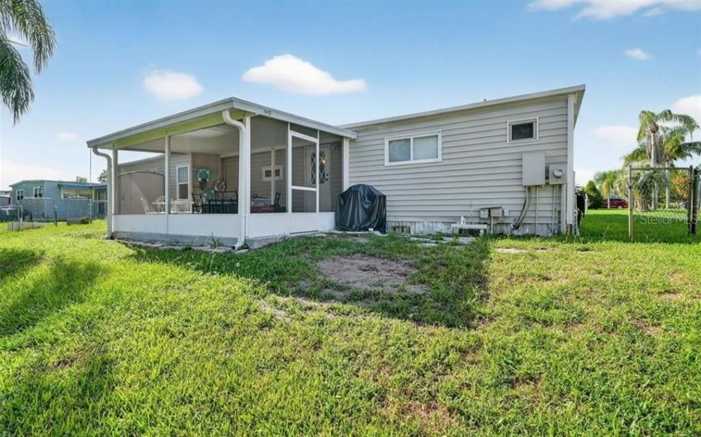 The exterior of a manufactured home features a screened-in porch and light-colored horizontal siding — 11905 LINDA AVENUE, TAVARES, FL