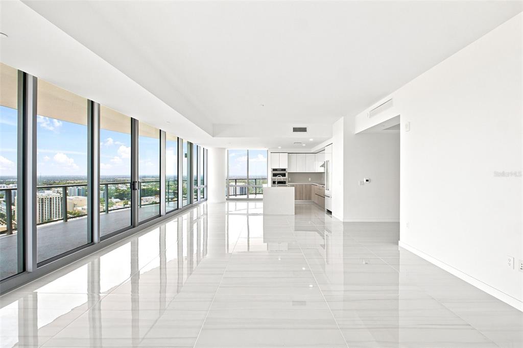 An open-concept living area with white tile floors, a modern kitchen, and floor-to-ceiling windows — 400 CENTRAL AVENUE UNIT 2901, ST PETERSBURG, FL