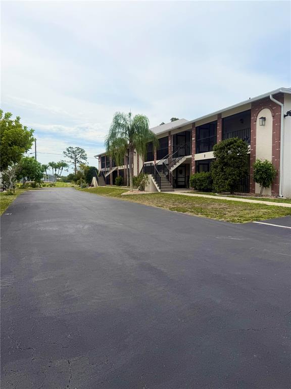 A two-story apartment building with exterior staircases and a paved parking lot in front — 1531 PLACIDA ROAD UNIT 202, ENGLEWOOD, FL