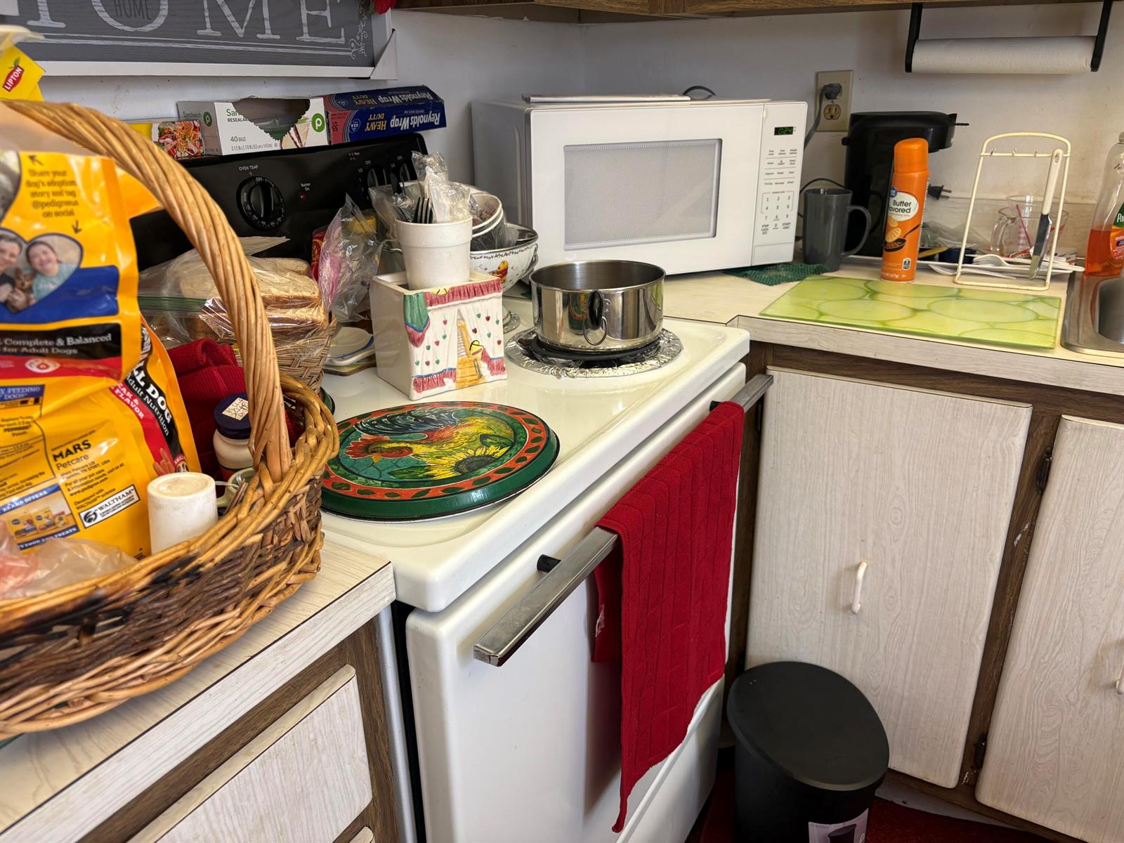A kitchen features a white stove, a microwave, a wicker basket, and light-colored cabinets — 862 Normandy R Trail # R, Delray Beach FL 33484, DELRAY BEACH, FL