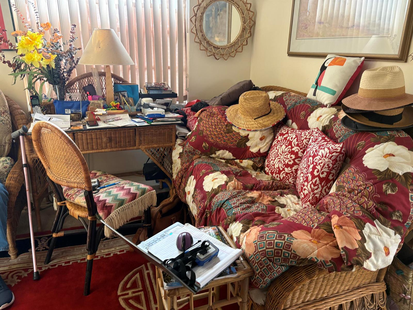 A cluttered living room features a wicker desk, a floral sofa, and a patterned rug — 862 Normandy R Trail # R, Delray Beach FL 33484, DELRAY BEACH, FL
