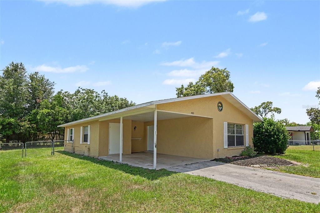 A single-story yellow house features a front carport and a concrete driveway — 483 WATER RUN, OCALA, FL