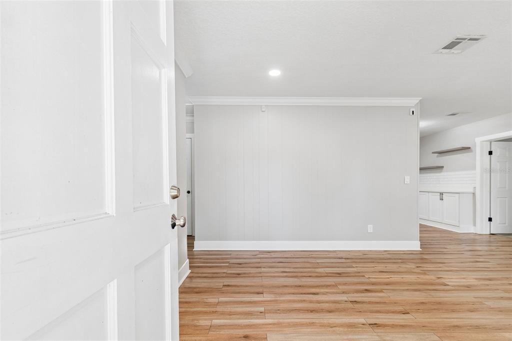 An interior view of a room with light gray walls and wood-look flooring — 1555 MAGNOLIA DRIVE, CLEARWATER, FL