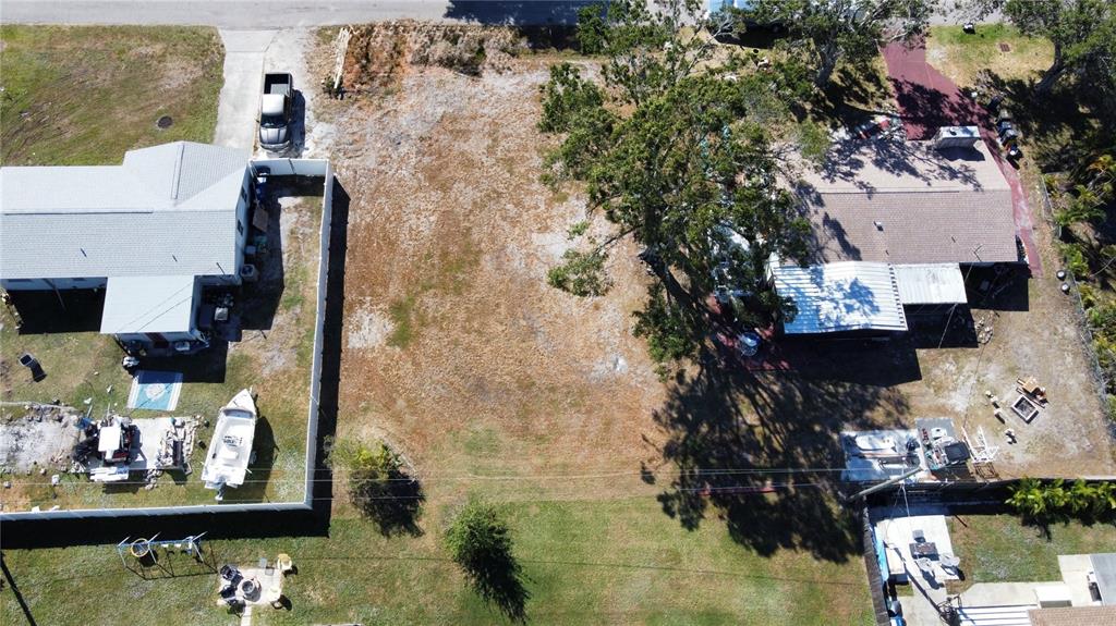 An aerial view shows a vacant rectangular lot situated between two residential properties — 408 51ST STREET W, PALMETTO, FL