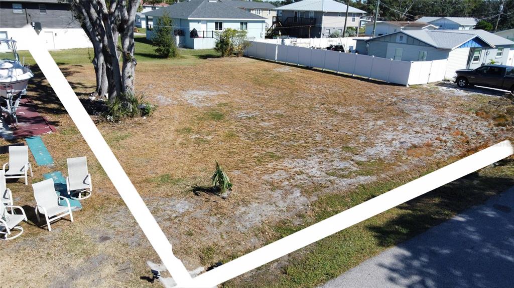 An aerial view shows a vacant, grassy residential lot outlined in white — 408 51ST STREET W, PALMETTO, FL