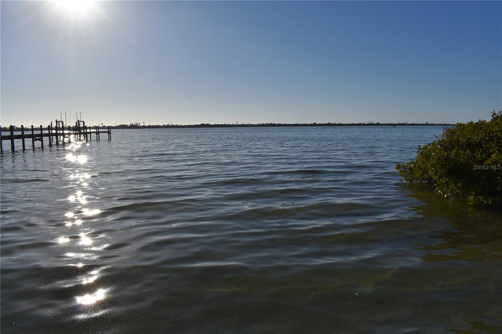 A wooden pier extends into a calm body of water under a bright sun — 175 W BAY STREET, ENGLEWOOD, FL