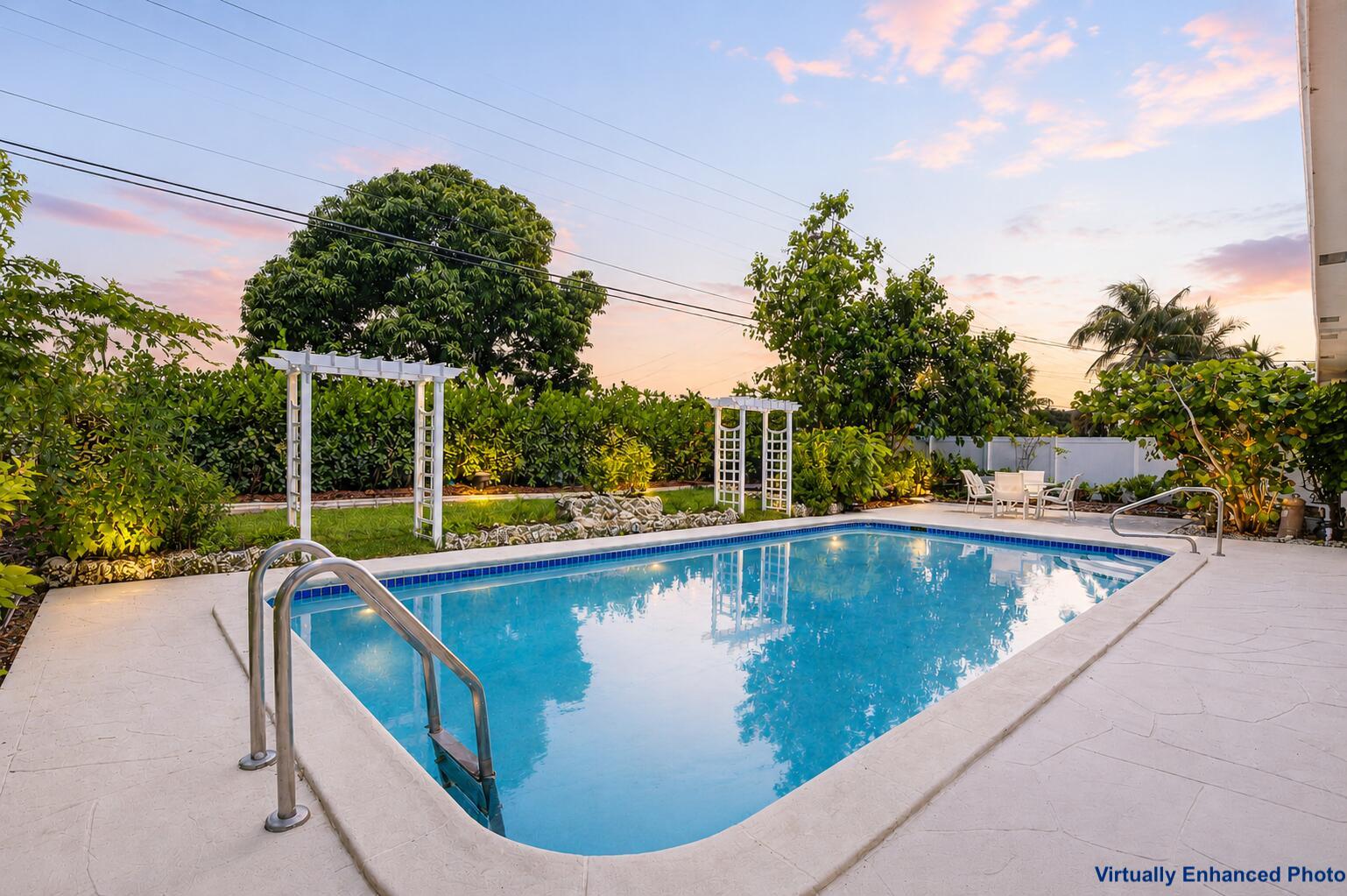 A rectangular swimming pool with a metal ladder sits on a patio near two white pergolas — 1207 SW 12th Avenue, Boca Raton FL 33486, BOCA RATON, FL