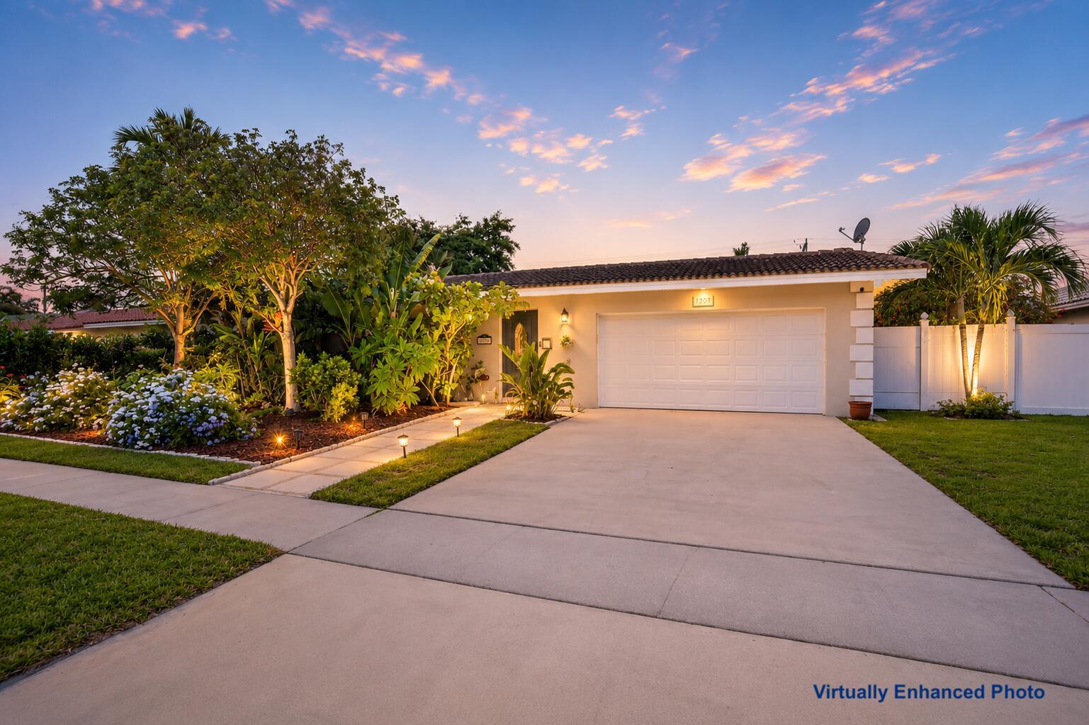 A single-story house with a white garage, concrete driveway, and landscaped front yard at dusk — 1207 SW 12th Avenue, Boca Raton FL 33486, BOCA RATON, FL