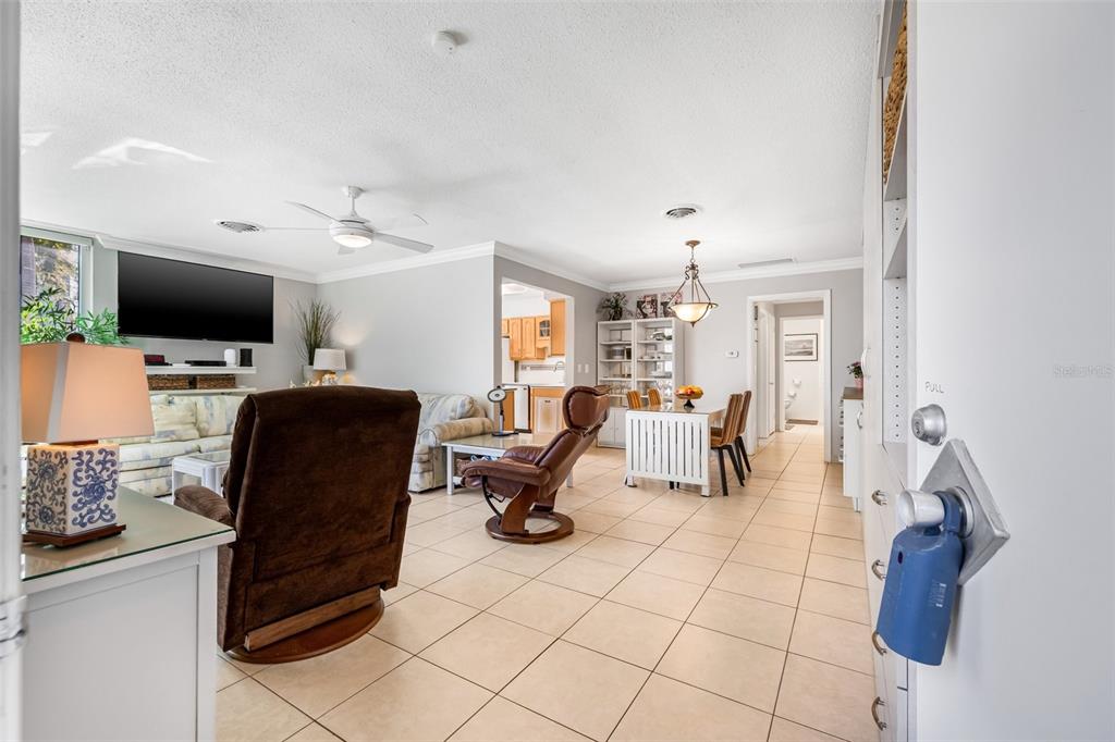 An open-concept living and dining area features tile flooring, a ceiling fan, and neutral walls — 615 10TH AVENUE NE UNIT 1, ST PETERSBURG, FL