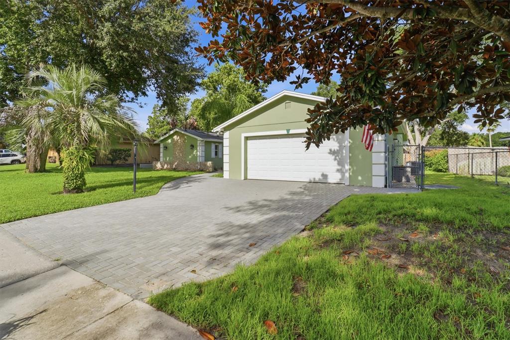 A light green house with a white garage door and a paved driveway — 644 PEACHWOOD DRIVE, ALTAMONTE SPRINGS, FL